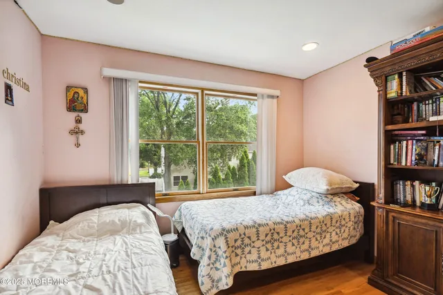 a bedroom with a bed a large window and a book shelf