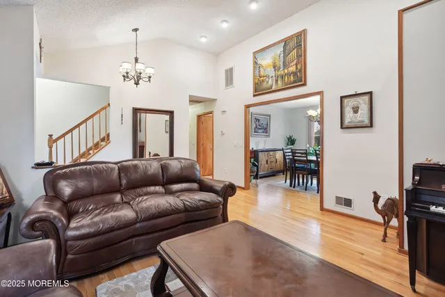a living room with furniture kitchen view and a wooden floor