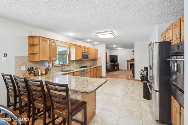 a kitchen with stainless steel appliances kitchen island granite countertop a refrigerator and cabinets