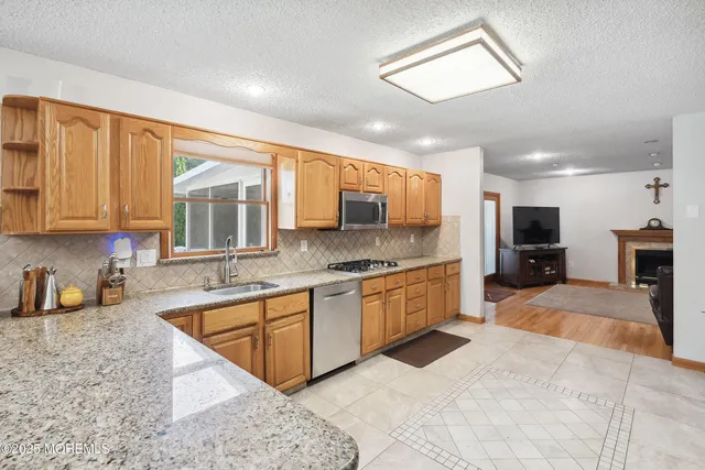 a large kitchen with stainless steel appliances granite countertop a sink and cabinets