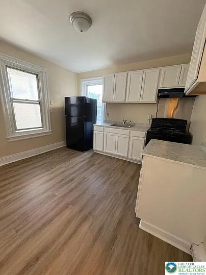 520 Fiot Avenue, Unit 2 Bethlehem, PA 18015 - Photo 2 of 23 a kitchen with a refrigerator a stove top oven a sink and cabinets with wooden floor