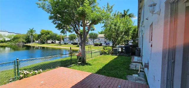 a view of a lake with a garden and large trees