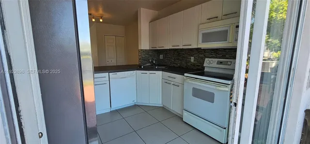 a kitchen with white cabinets and white appliances