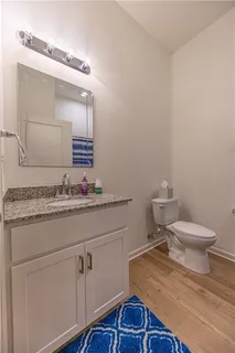 a bathroom with a granite countertop toilet sink and mirror