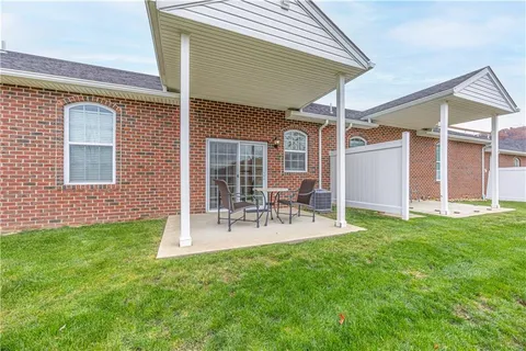 a view of a patio with table and chairs and wooden fence