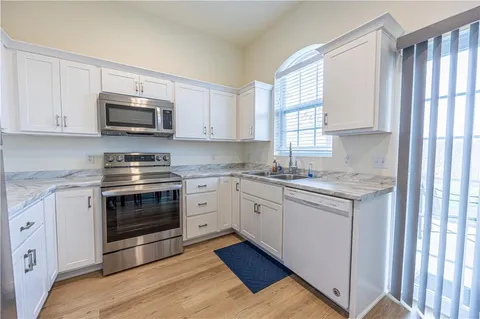 a kitchen with stainless steel appliances granite countertop a stove a sink and a microwave