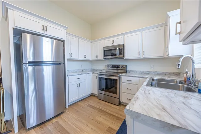 a kitchen with cabinets stainless steel appliances and a counter space