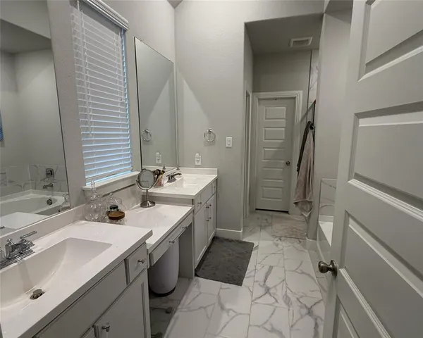 a spacious bathroom with a double vanity sink a mirror and a shower