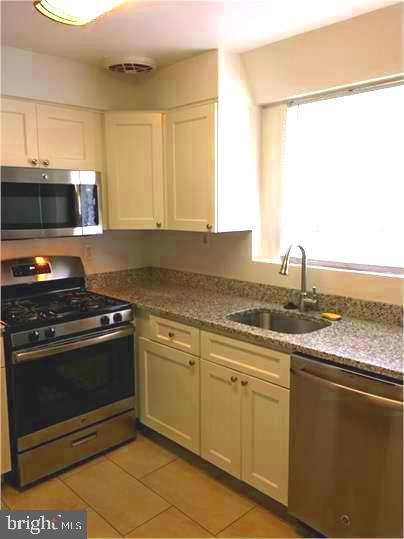 5319 Pooks Hill Road, Unit 1 Bethesda, MD 20814 - Photo 12 of 37 a kitchen with granite countertop a sink stainless steel appliances and cabinets