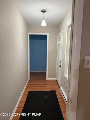 a living room with a large window wooden floor and a rug