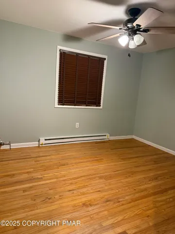 a view of a room with wooden floor and fan
