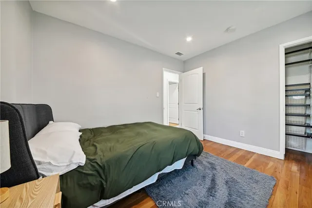 a bedroom with a bed and a dresser with mirror