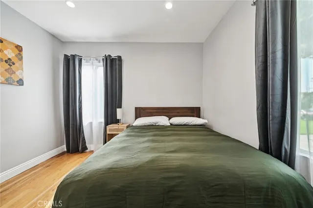 a bedroom with a bed and wooden floor