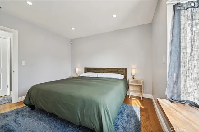 a spacious bedroom with a bed a fireplace and a television