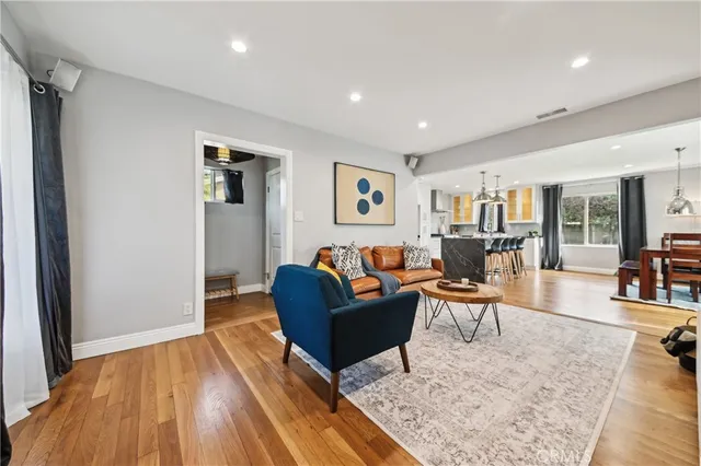 a living room with furniture and a wooden floor