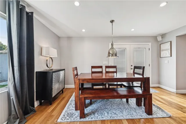 a kitchen with stainless steel appliances a table chairs refrigerator and cabinets