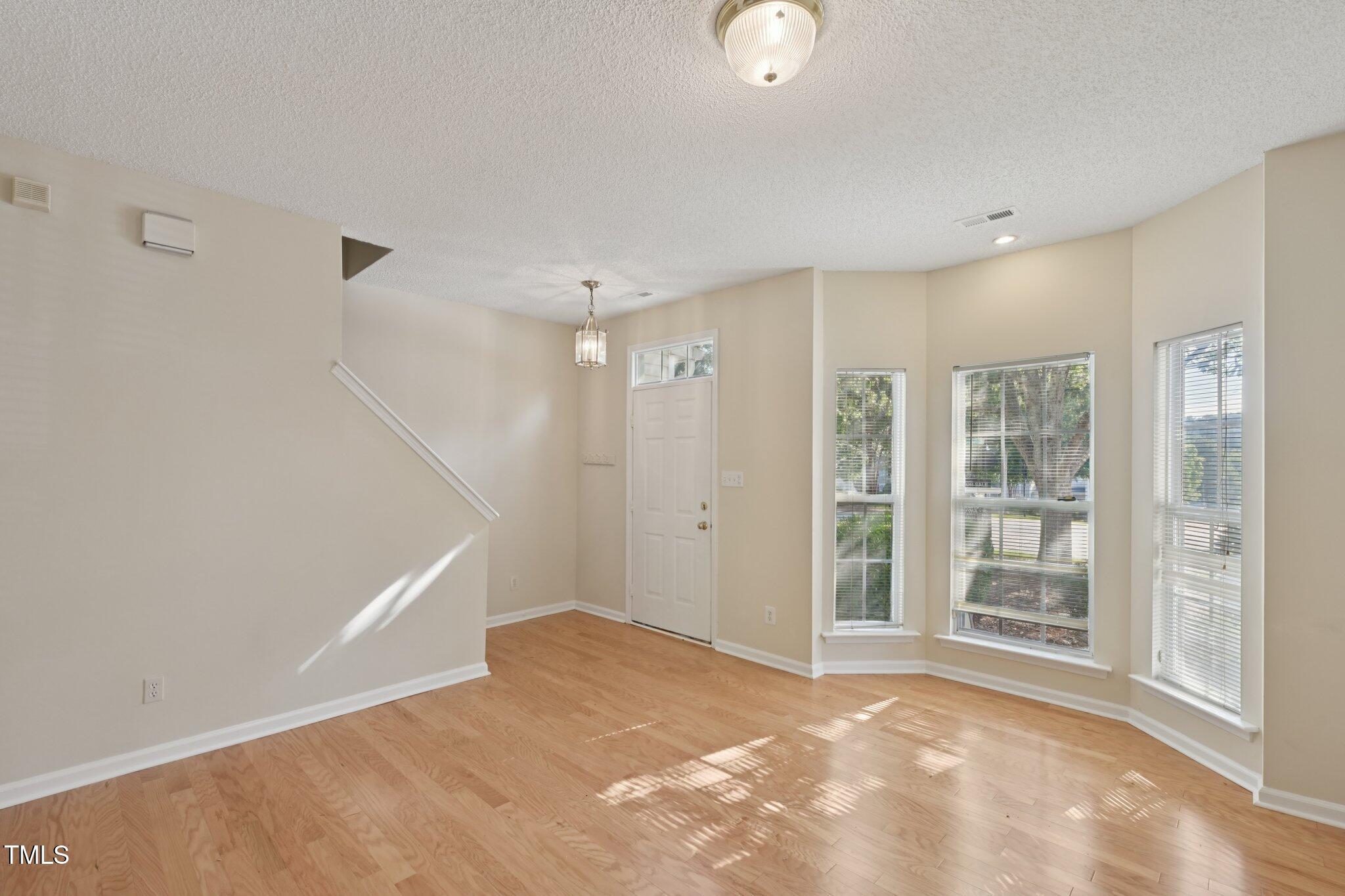 1031 Lake Moraine Place Raleigh, NC 27607 - Photo 6 of 33 a view of an empty room with wooden floor and a window