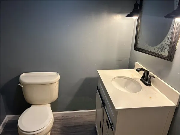 a bathroom with a sink a toilet and a mirror