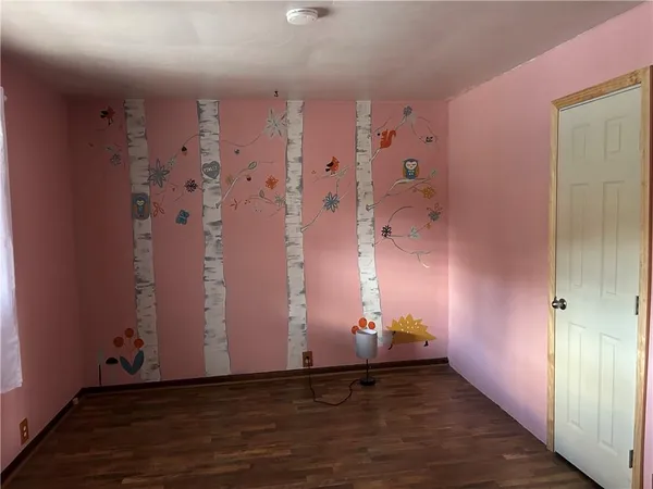 a view of a livingroom with wooden floor and a window