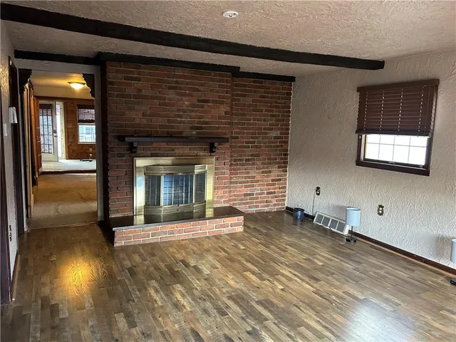 a view of a hallway with wooden floor and a fireplace