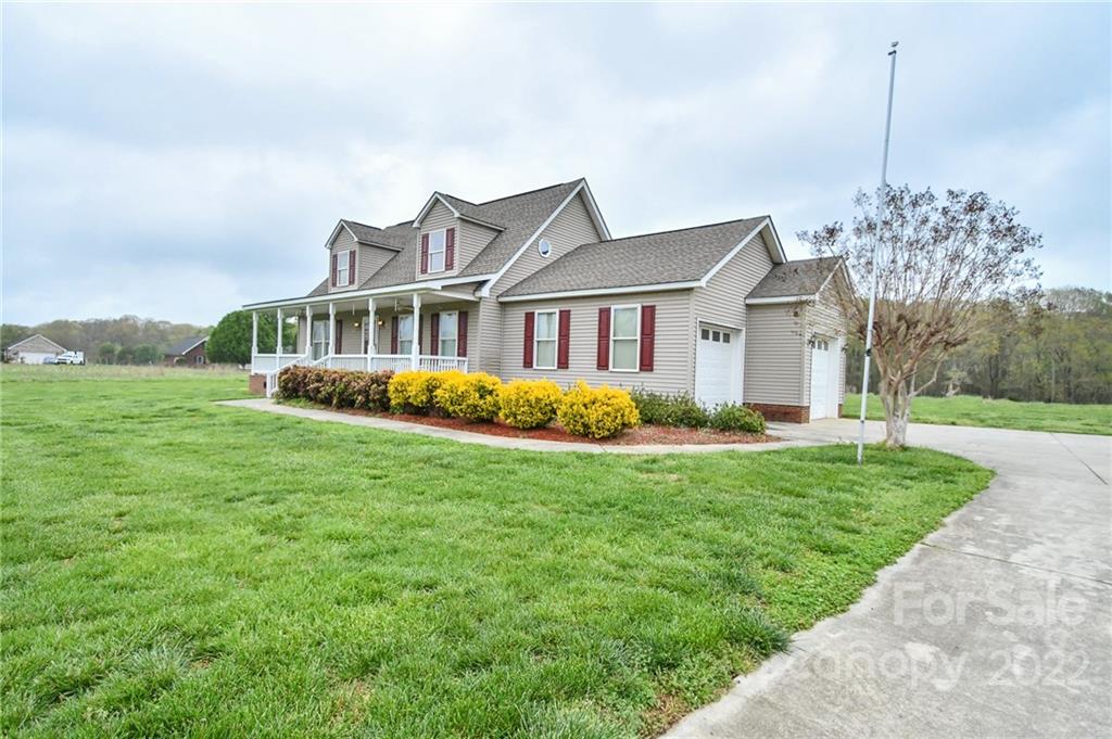 3916 Old Camden Road Monroe, NC 28110 - Photo 3 of 18 a front view of a house with a yard and potted plants