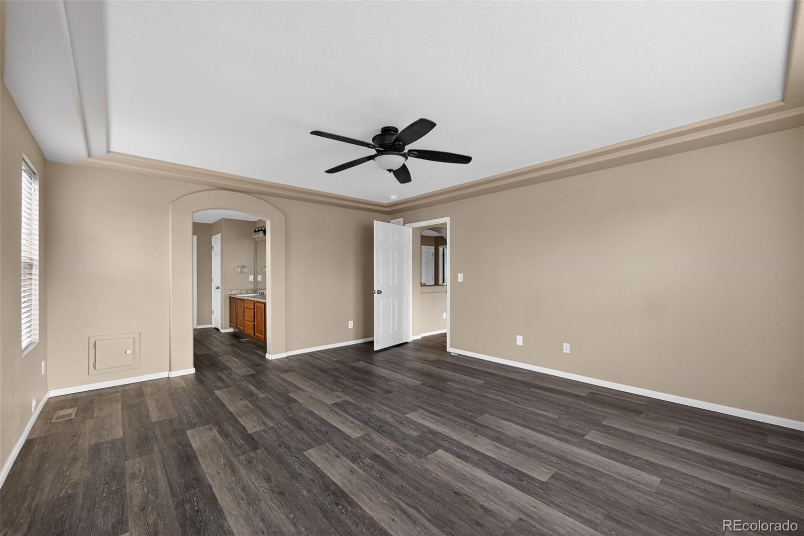 5085 Ridgewood Drive Johnstown, CO 80534 - Photo 14 of 30 a view of an empty room with wooden floor and a ceiling fan