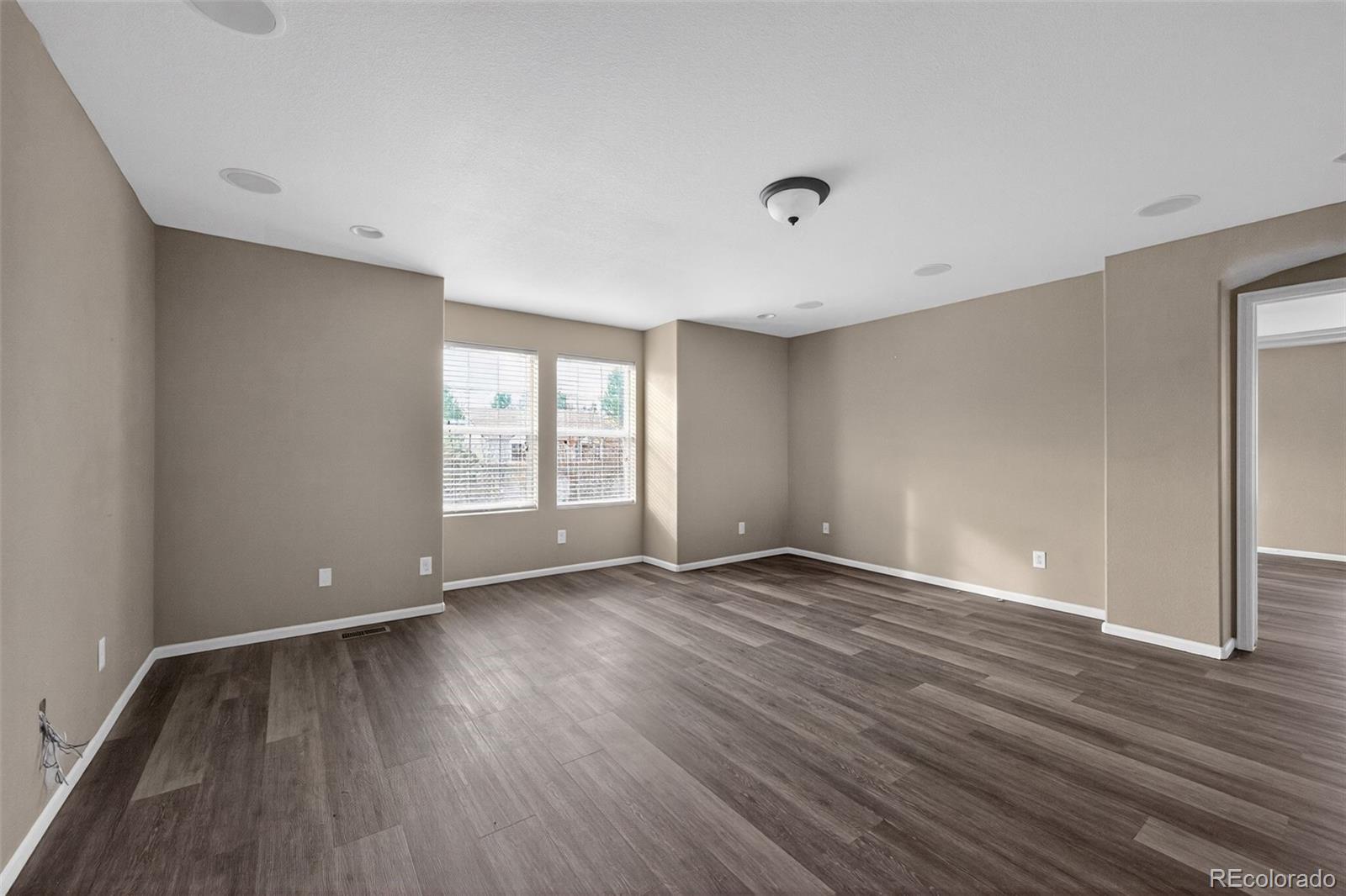 5085 Ridgewood Drive Johnstown, CO 80534 - Photo 18 of 30 a view of an empty room with wooden floor and a window