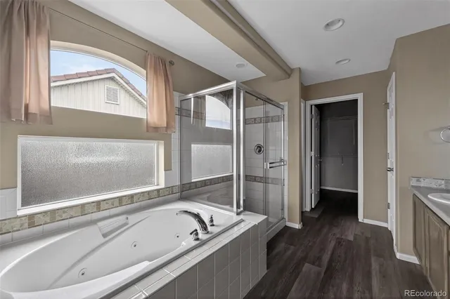 a bathroom with a tub a sink and a large mirror