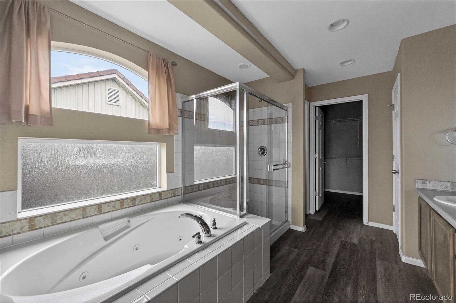 5085 Ridgewood Drive Johnstown, CO 80534 - Photo 25 of 30 a bathroom with a tub a sink and a large mirror