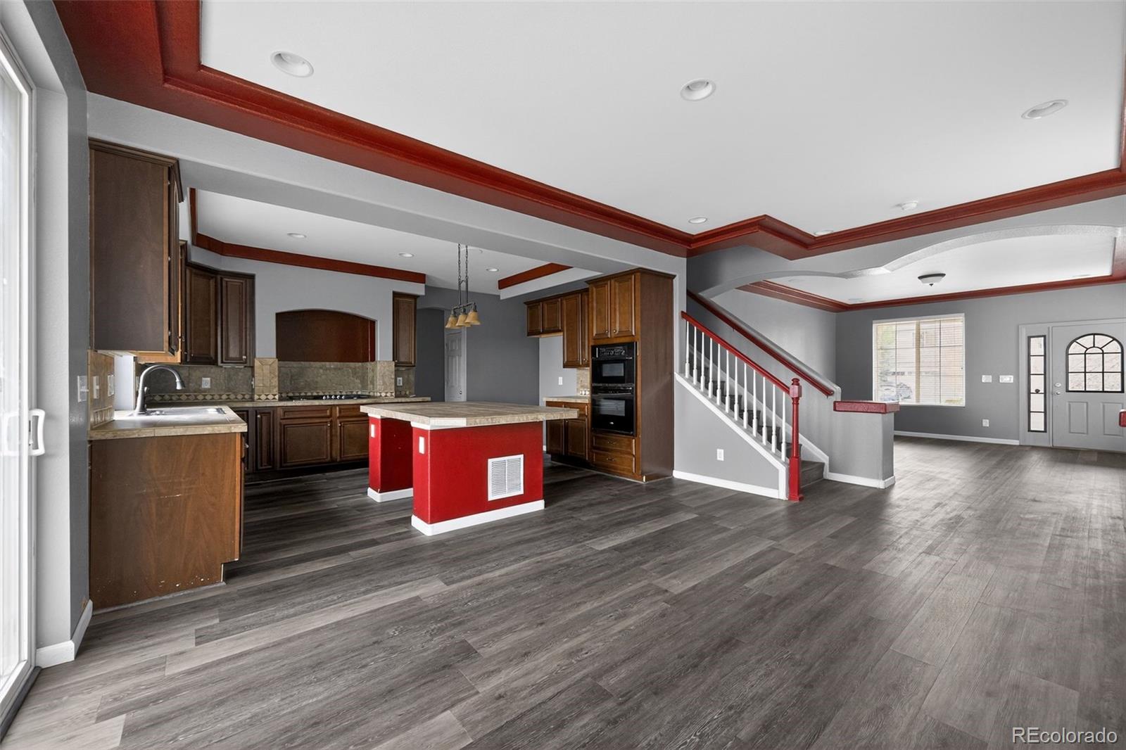 5085 Ridgewood Drive Johnstown, CO 80534 - Photo 4 of 30 a kitchen with stainless steel appliances kitchen island wooden floors and view living room