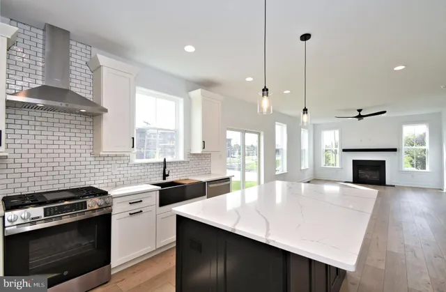 a kitchen with kitchen island a stove a refrigerator a sink and a fireplace