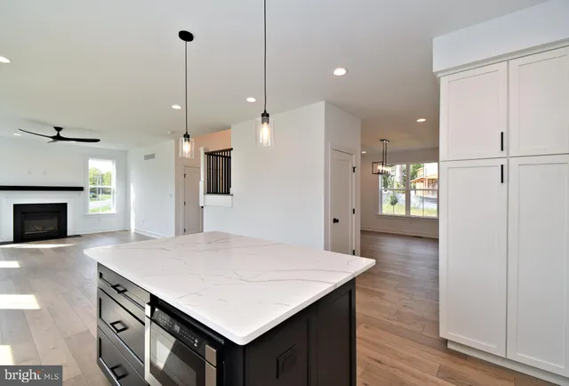 a kitchen with a sink a stove a refrigerator and white cabinets with wooden floor