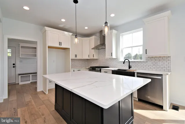 a view of an empty room with wooden floor a fireplace and a window