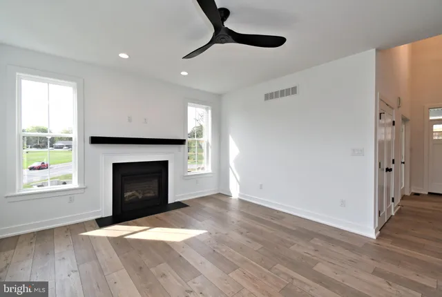 a view of a hallway with wooden floor and closet