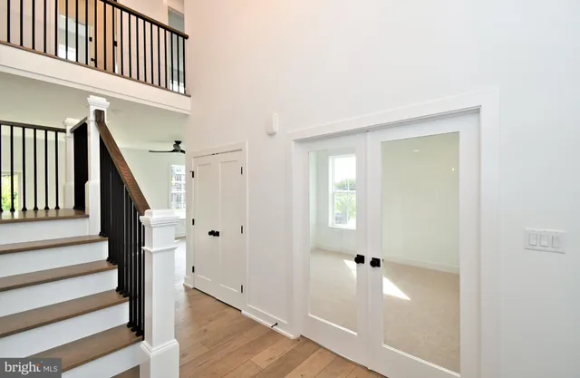 a view of staircase with lots of frames on wall and wooden floor