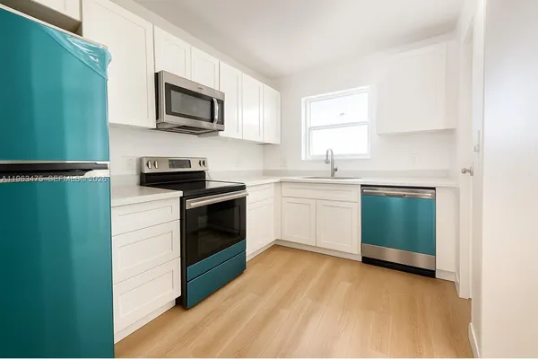 a kitchen with a sink a microwave and cabinets