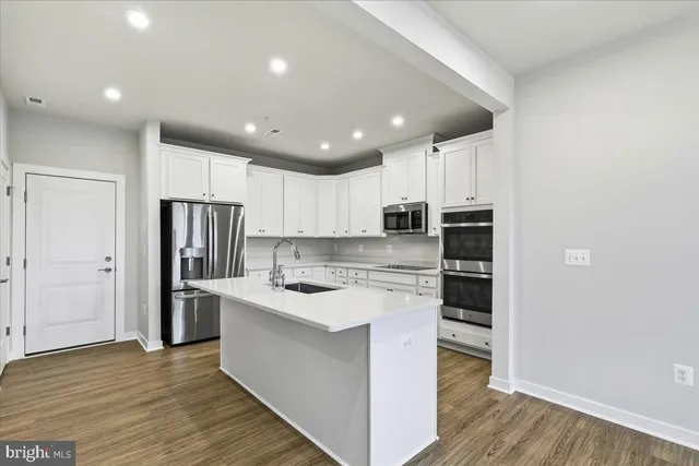 a kitchen with stainless steel appliances granite countertop a refrigerator and a stove top oven