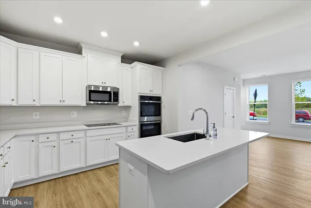 a kitchen with sink a microwave and cabinets
