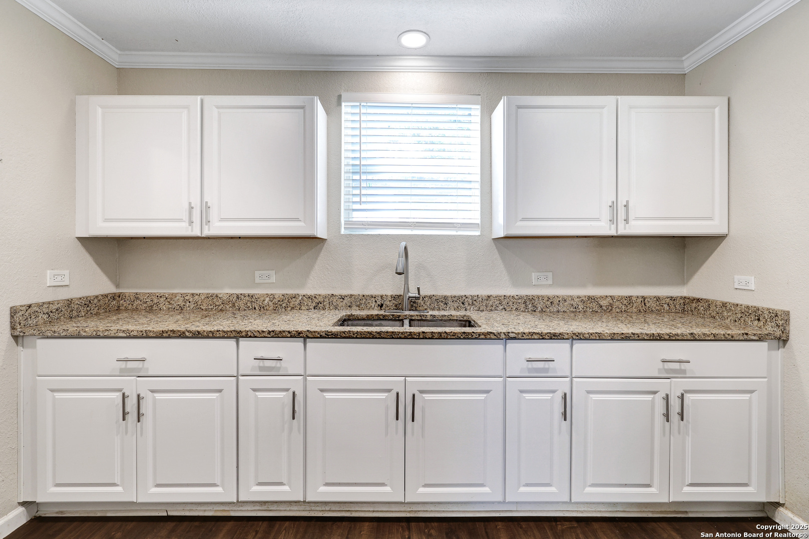 507 Hayden Avenue Devine, TX 78016 - Photo 12 of 26 a kitchen with granite countertop white cabinets and a sink