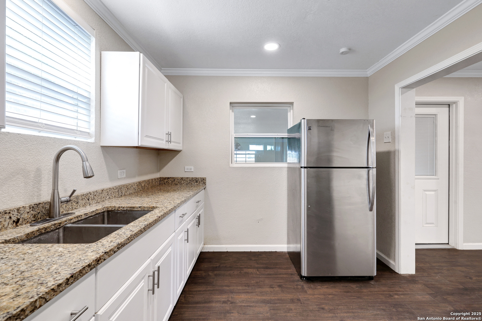507 Hayden Avenue Devine, TX 78016 - Photo 13 of 26 a kitchen with a refrigerator a sink and cabinets