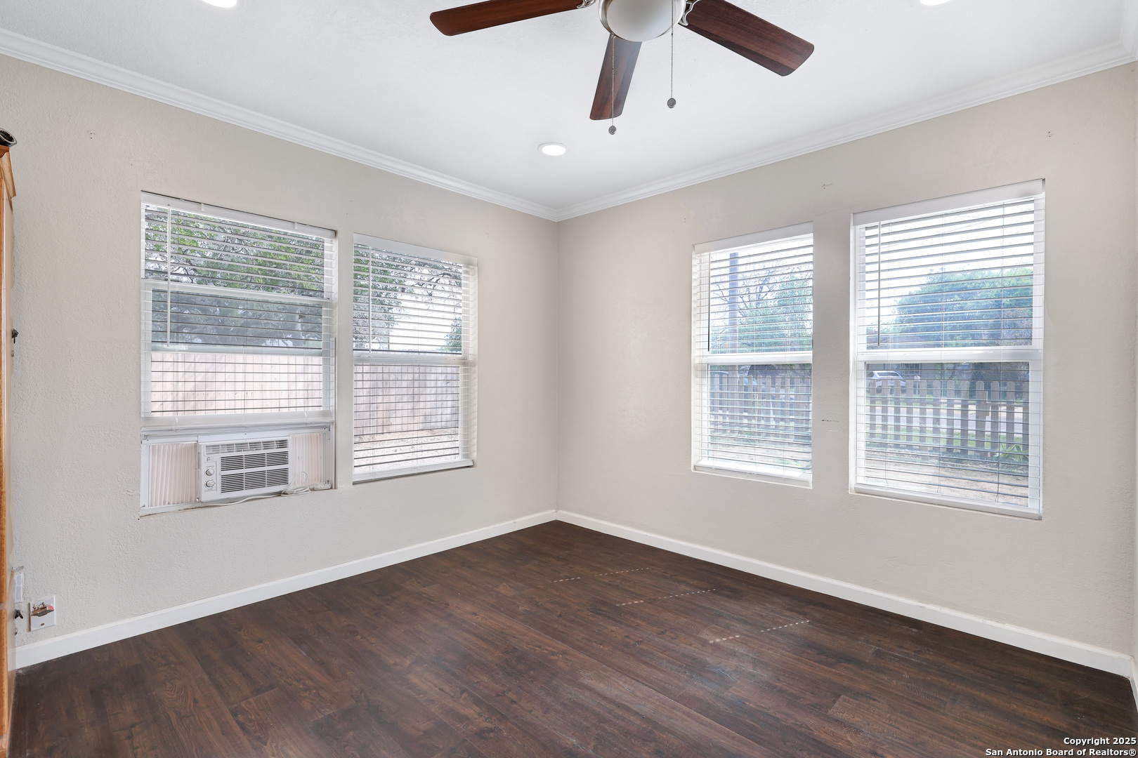 507 Hayden Avenue Devine, TX 78016 - Photo 15 of 26 a view of an empty room with wooden floor and a window