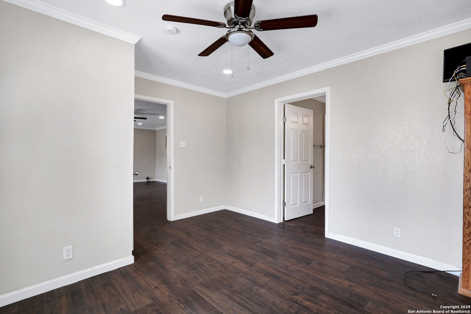 507 Hayden Avenue Devine, TX 78016 - Photo 16 of 26 an empty room with wooden floor and a ceiling fan