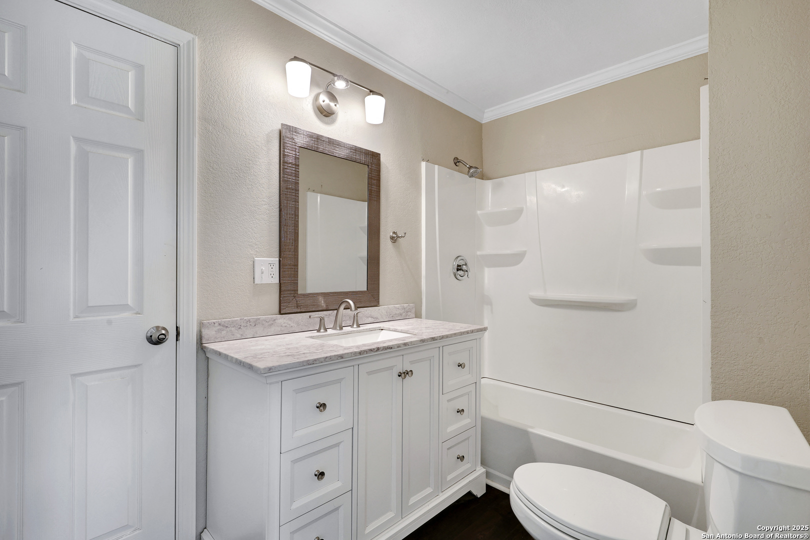 507 Hayden Avenue Devine, TX 78016 - Photo 17 of 26 a bathroom with a granite countertop toilet sink and mirror