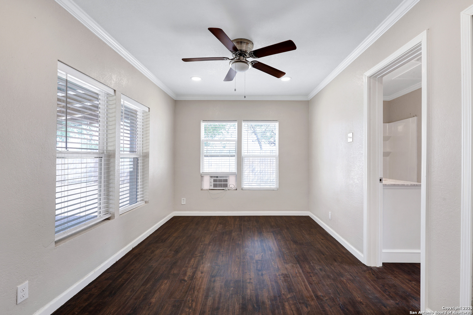 507 Hayden Avenue Devine, TX 78016 - Photo 18 of 26 a view of an empty room with wooden floor and a window