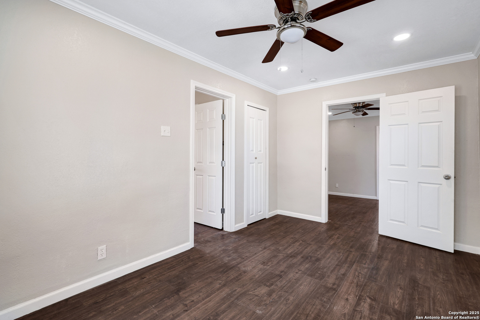 507 Hayden Avenue Devine, TX 78016 - Photo 19 of 26 an empty room with wooden floor a ceiling fan and windows