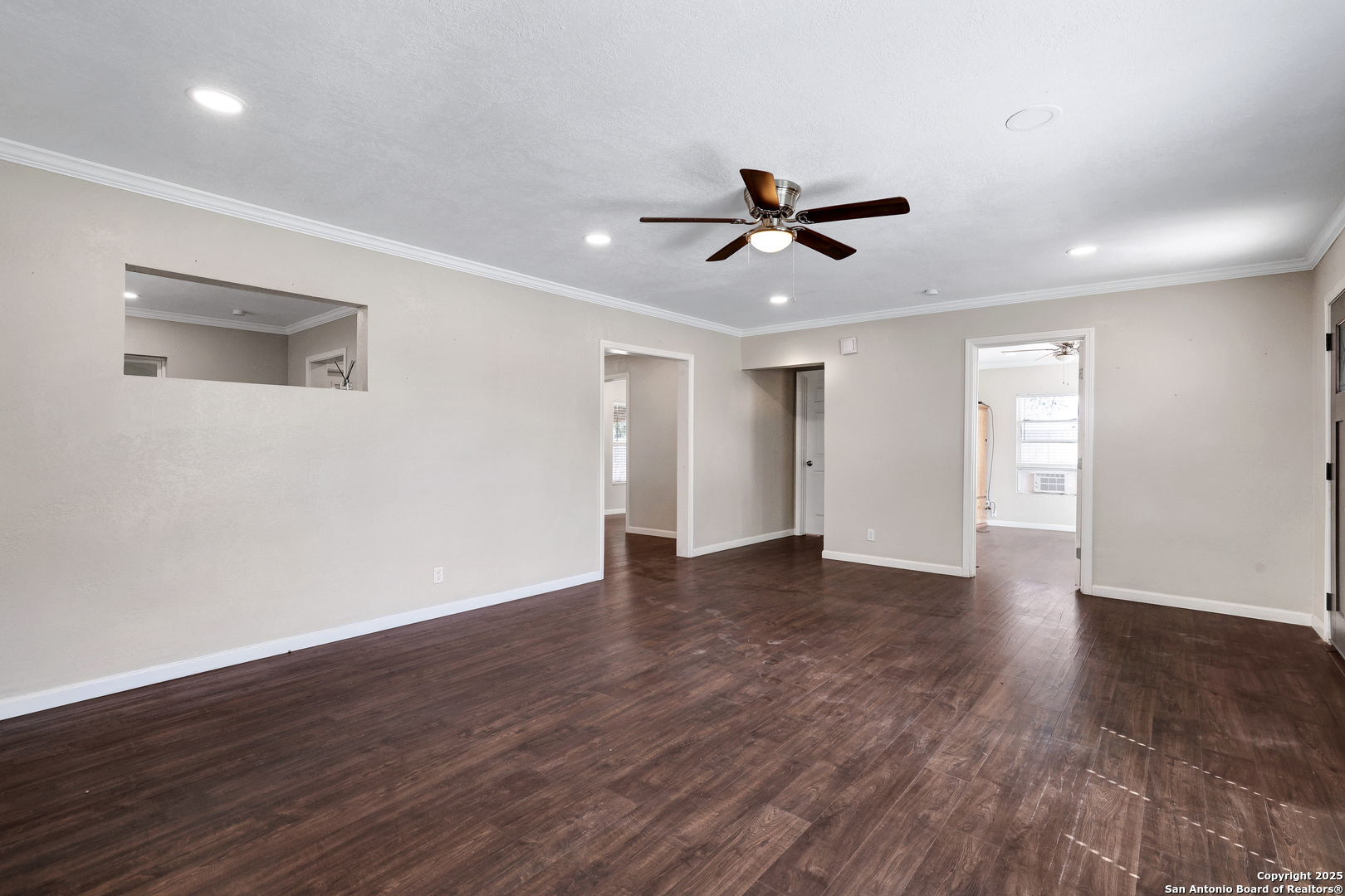 507 Hayden Avenue Devine, TX 78016 - Photo 7 of 26 a view of empty room with wooden floor and ceiling fan