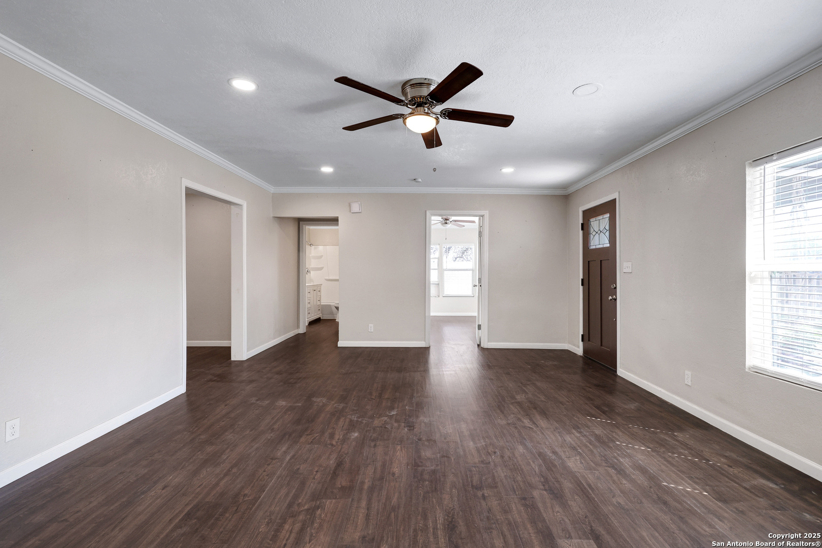 507 Hayden Avenue Devine, TX 78016 - Photo 8 of 26 a view of an empty room with wooden floor and window