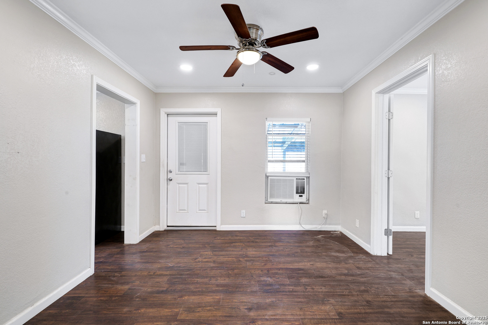 507 Hayden Avenue Devine, TX 78016 - Photo 9 of 26 wooden floor in an empty room with a window