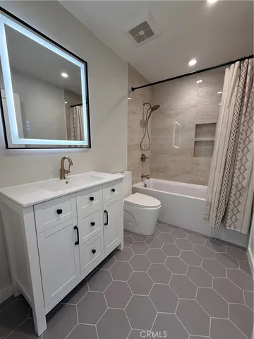 a bathroom with a double vanity sink mirror and bathtub