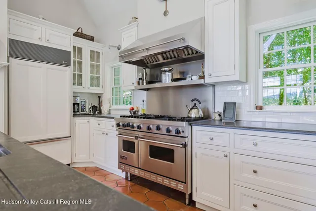 a kitchen with kitchen island granite countertop a sink and white cabinets